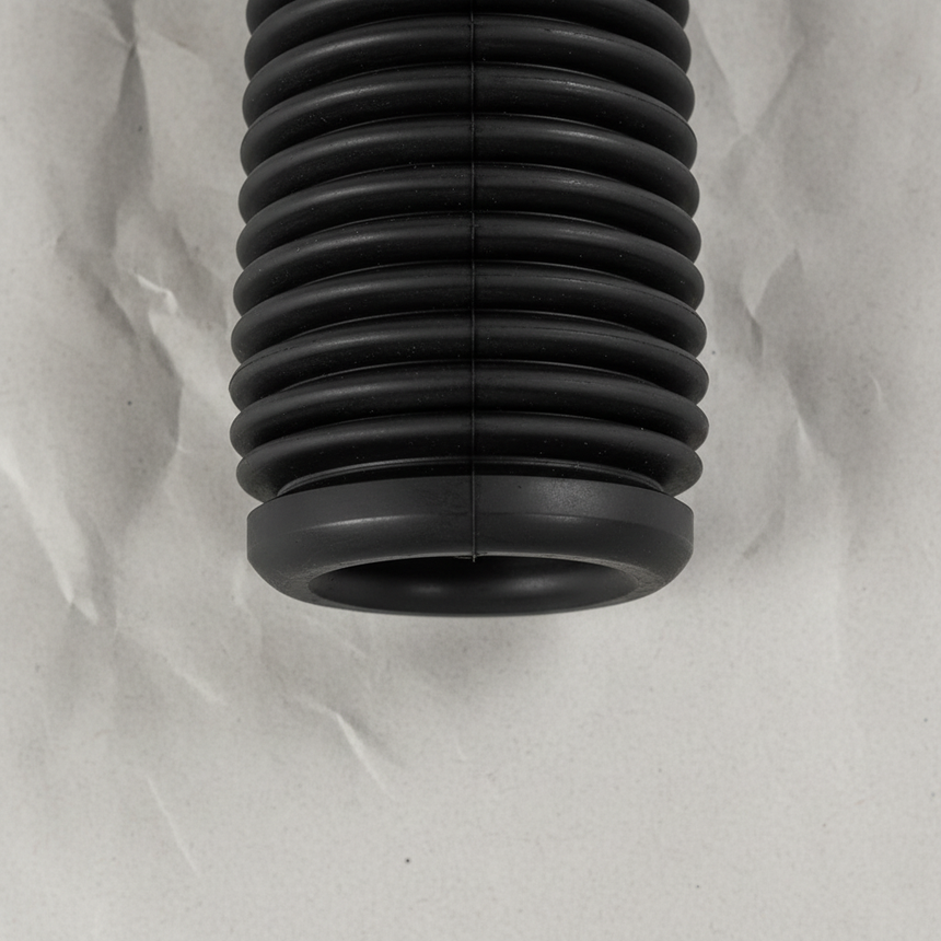 Bottom macro crop of front suspension strut dust cover on light grey wrinkled kraft paper