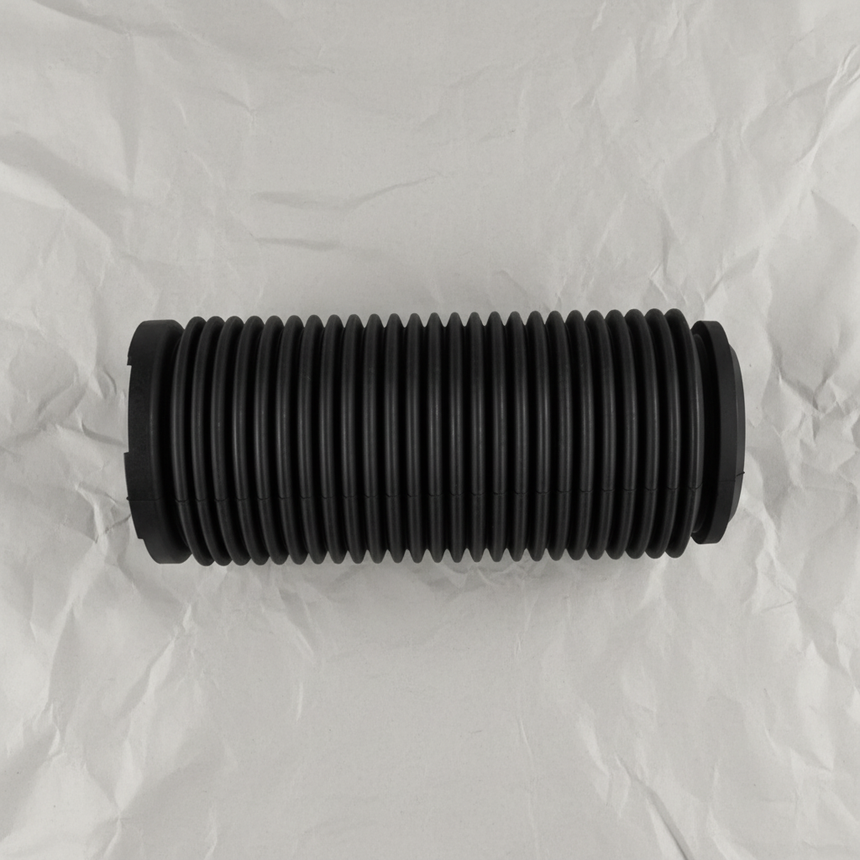 Full view of front suspension strut dust cover on light grey wrinkled kraft paper