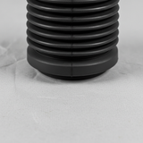 Lower-middle macro crop of front suspension strut dust cover on light grey wrinkled kraft paper