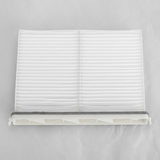 Middle macro crop of Mazda CX-9 cabin air filter on light grey wrinkled kraft paper