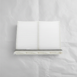 Full view of Mazda CX-9 cabin air filter on light grey wrinkled kraft paper