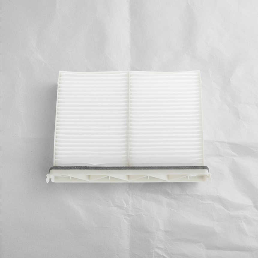 Full view of Mazda CX-9 cabin air filter on light grey wrinkled kraft paper