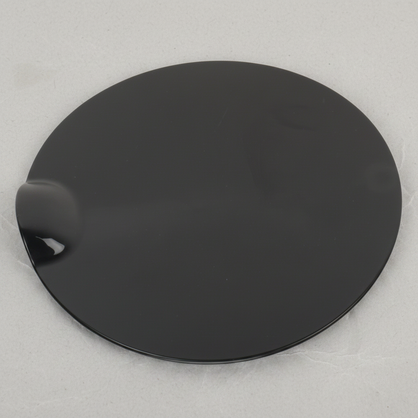 Bottom macro crop of Ford F-150 fuel tank filler door on light grey wrinkled kraft paper