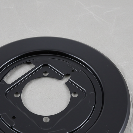 Brake backing plate top section macro crop on light grey wrinkled kraft paper background