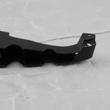 Bottom macro crop of Dodge Charger rear bumper fascia support bracket on light grey wrinkled kraft paper