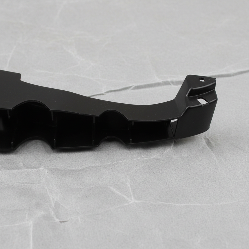 Bottom macro crop of Dodge Charger rear bumper fascia support bracket on light grey wrinkled kraft paper